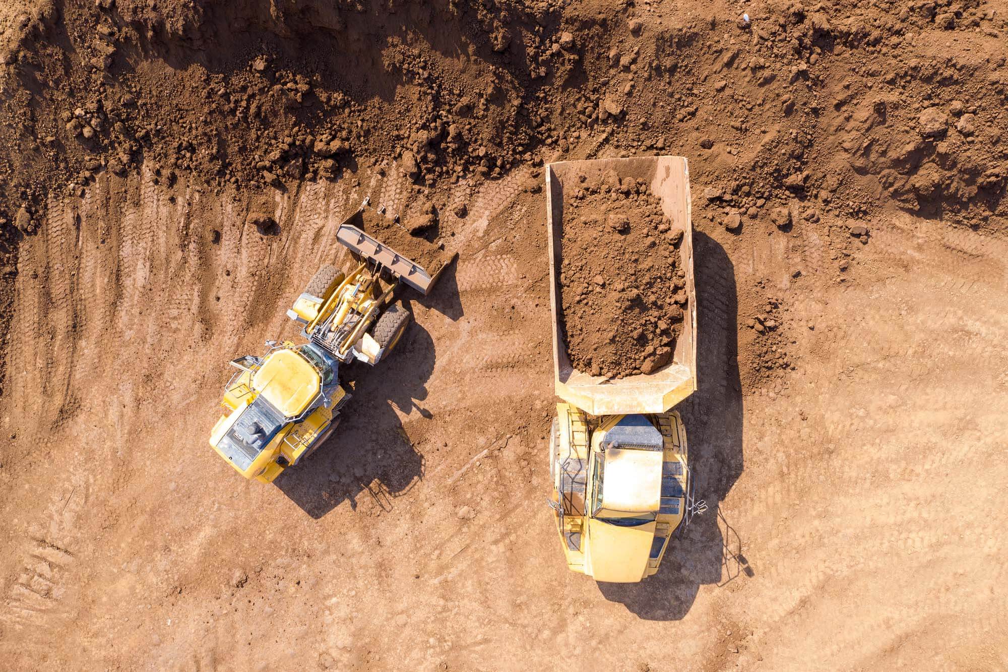 Excavator Loading Soil Onto An Articulated Hauler Truck, Top Dow